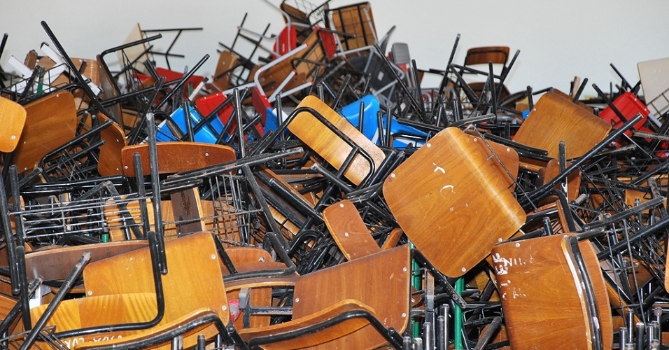 Cadeiras e mesas se amontoam no pátio da Escola Mota Trigueiros, sem a mínima condição de manutenção e armazenamento